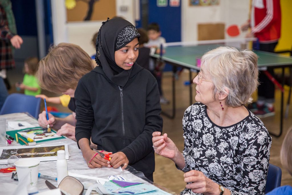 Older woman doing crafts with a young girl