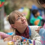 Close up of two children doing a craft activity with an adult