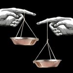 Black background with hand drawn hand pointing at each other holding brass weighing scales