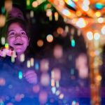 A person with a look of wonder is surrounded by bright twinkling lights.